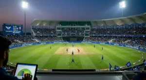 Aerial wide-angle view of Lucknow Ekana Cricket Stadium during a floodlit IPL night match between LSG and RCB. The scoreboard displays "Pitch Report: Slow & Two-Paced, Spin Assistance." LED boundary boards around the ground read "Ekana Pitch Insights," "Spin is Key," and "Bowling-Friendly Conditions." A fan in the foreground analyses match data on a tablet. The dry, two-toned pitch surface is clearly visible at the centre of the ground.