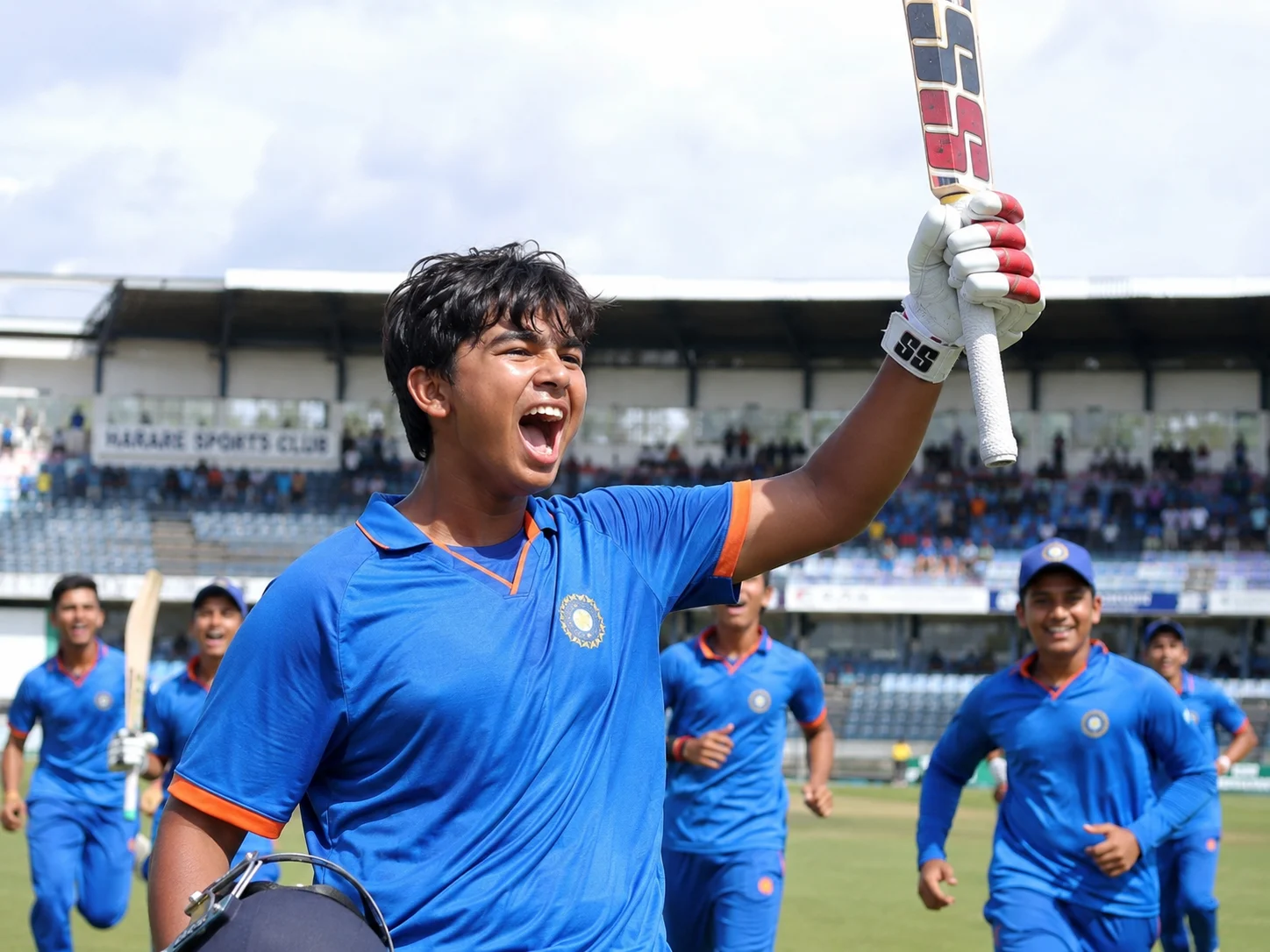 Vaibhav Sooryavanshi celebrates India’s 2026 Under-19 World Cup title with his bat raised as teammates approach.