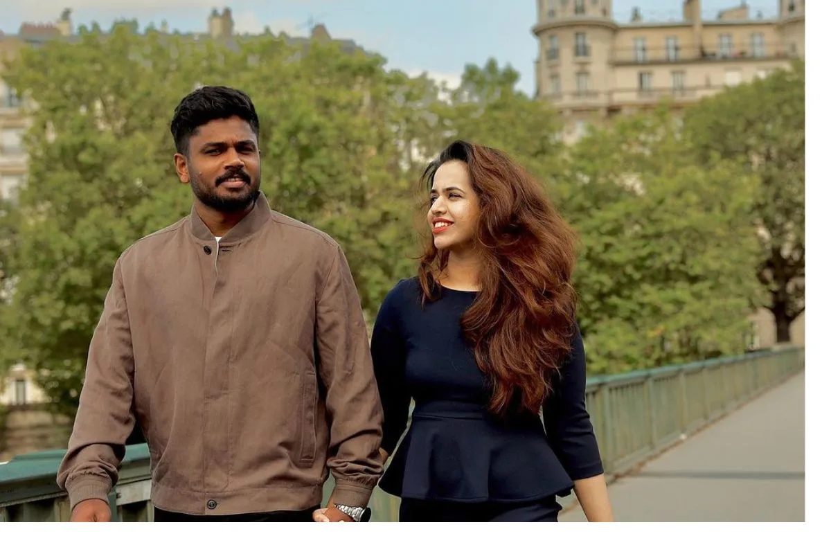 Sanju Samson and his wife Charulatha Remesh walking together outdoors.