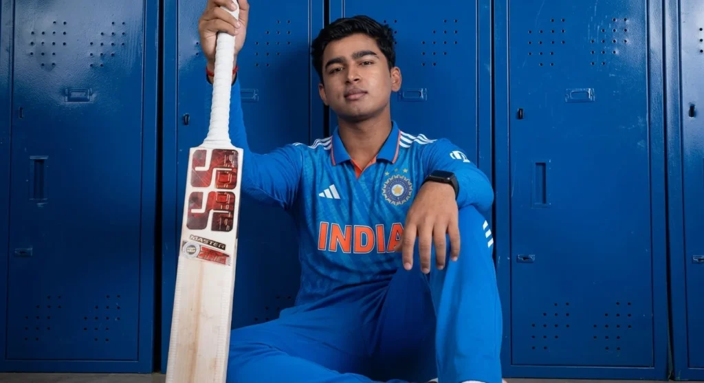 Young Indian top-order batter in blue India cricket kit seated beside a bat in a locker room for a Vaibhav Sooryavanshi biography.