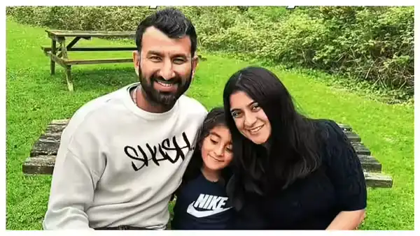 Family photograph accompanying Cheteshwar Pujara’s personal life story, showing him with his wife and young daughter outdoors.