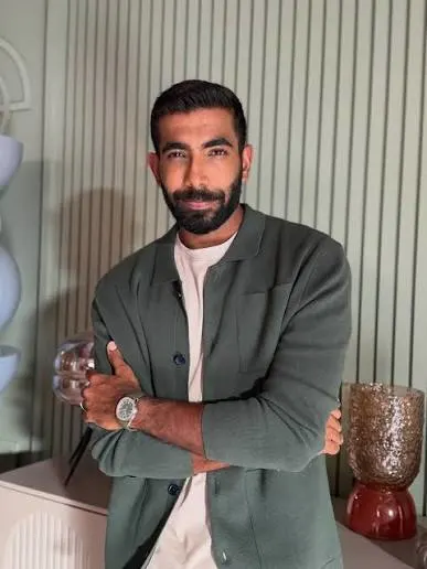 Indian cricketer posing in a smart casual outfit and luxury watch for a Jasprit Bumrah net worth 2026 lifestyle feature.
