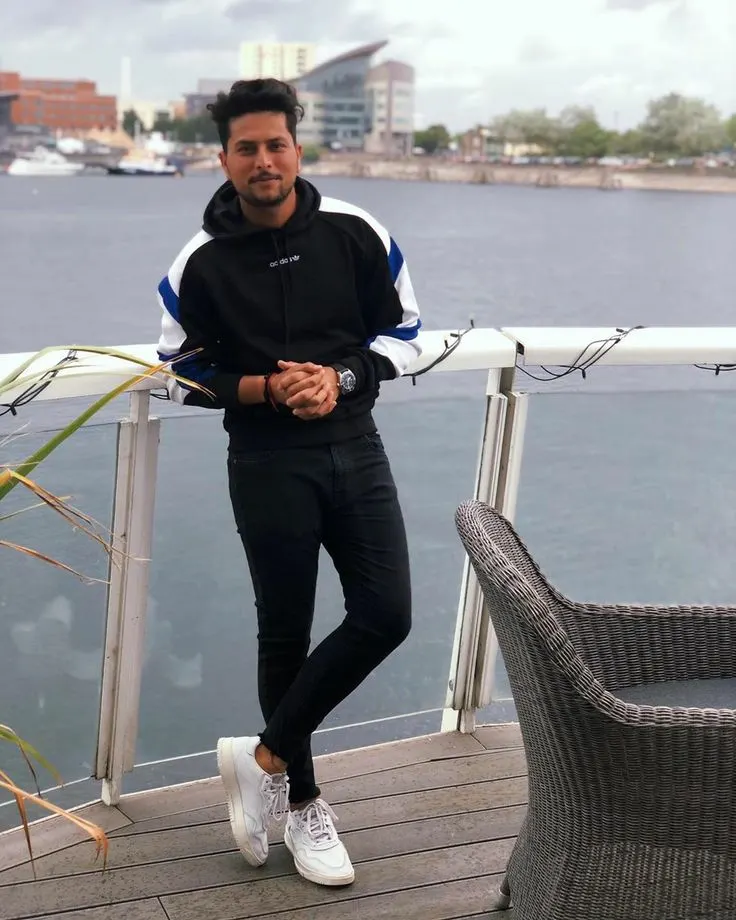 Indian cricketer in casual attire by the waterfront, accompanying a feature on Kuldeep Yadav’s ₹30–40 crore estimated net worth in 2026.