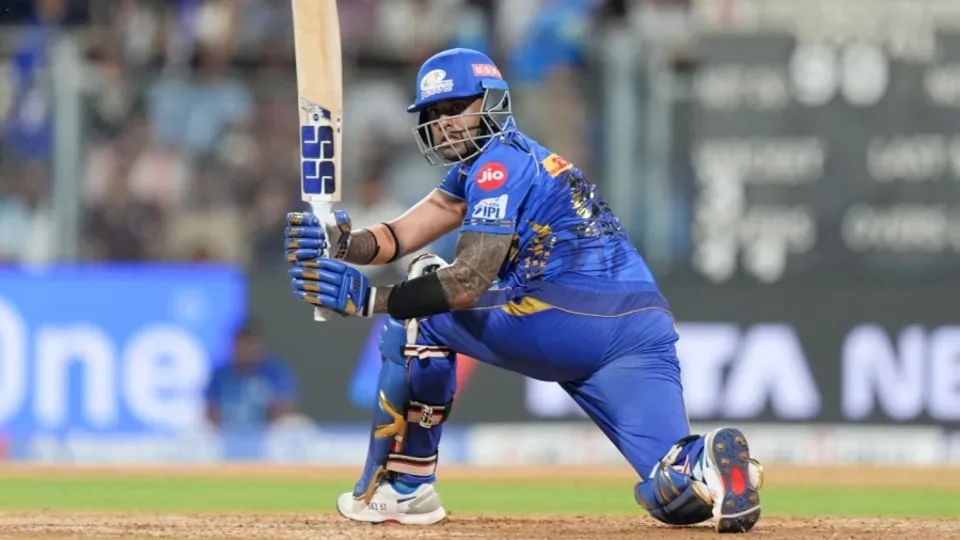 Suryakumar Yadav playing a sweep shot for Mumbai Indians during an IPL match.