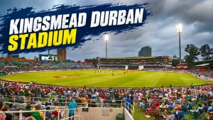 Kingsmead Stadium in Durban during a cricket match, showing the pitch, floodlights, stands, and spectators under cloudy skies.