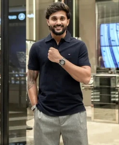 Nitish Kumar Reddy dressed casually in a black polo shirt and wearing a luxury watch, representing his growing endorsement and commercial profile beyond cricket.