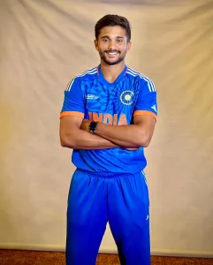 Nitish Kumar Reddy posing in India’s blue cricket kit, representing his rise as a right-handed batter and right-arm medium-fast all-rounder from Andhra Pradesh.