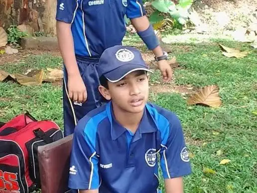 Childhood photo of young Devdutt Padikkal wearing a blue cricket uniform and cap during his early cricketing years.