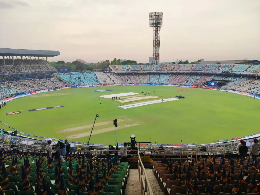 Wide-angle view of Eden Gardens Stadium in Kolkata showing the cricket pitch, green outfield, and large seating stands before a match, highlighting its balanced pitch conditions and big ground dimensions.