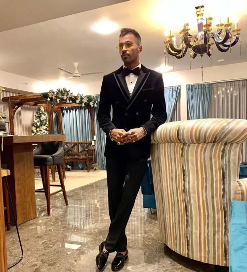 Hardik Pandya wearing a black tuxedo inside a luxury home, representing his wealth and lifestyle.