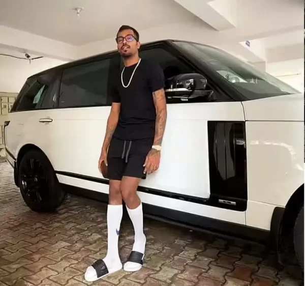 Hardik Pandya standing beside a white Range Rover from his reported luxury car collection.