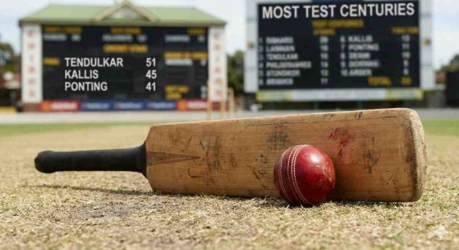Highest Centuries in Test Cricket graphic showing a cricket bat and red ball on the pitch, with a scoreboard in the background highlighting legends like Sachin Tendulkar, Jacques Kallis, and Ricky Ponting among players with the most centuries in Test cricket.