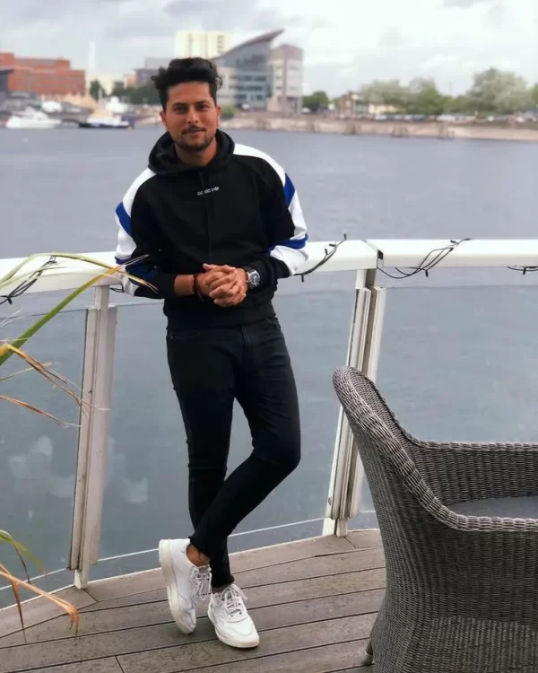 Indian cricketer in casual attire by the waterfront, accompanying a feature on Kuldeep Yadav’s ₹30–40 crore estimated net worth in 2026.