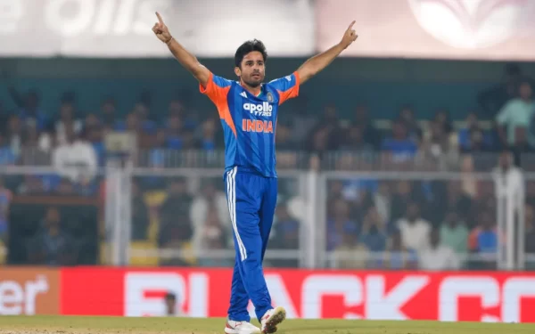 Indian leg-spinner celebrates a wicket in India’s blue T20 kit with both arms raised during an international cricket match.