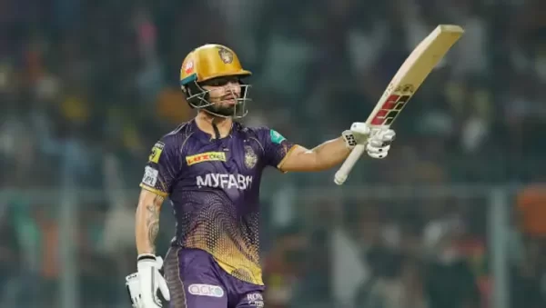 inku Singh raising his bat in a Kolkata Knight Riders jersey during an IPL match.