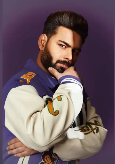 Rishabh Pant posing in a stylish varsity jacket during a professional lifestyle photoshoot.