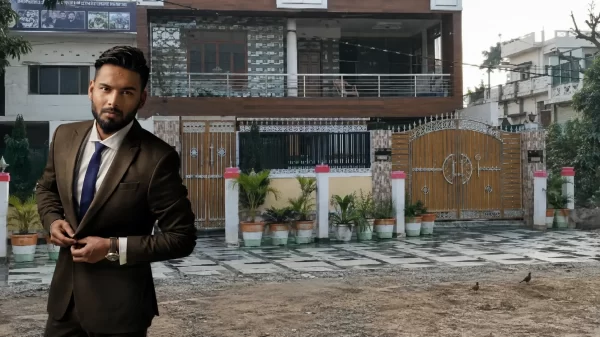 Rishabh Pant standing in formal attire outside his family house in Roorkee, Uttarakhand.