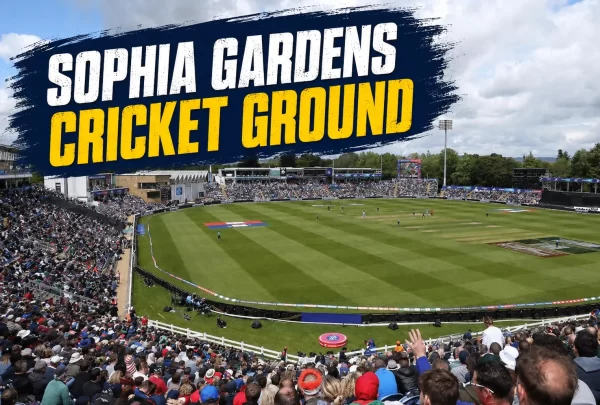 Wide view of Sophia Gardens Cricket Ground in Cardiff, showing the green cricket field, pitch, packed spectator stands, floodlights, and cloudy skies.