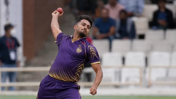 Umran Malik bowling in a purple Kolkata Knight Riders-style kit during a franchise cricket match.